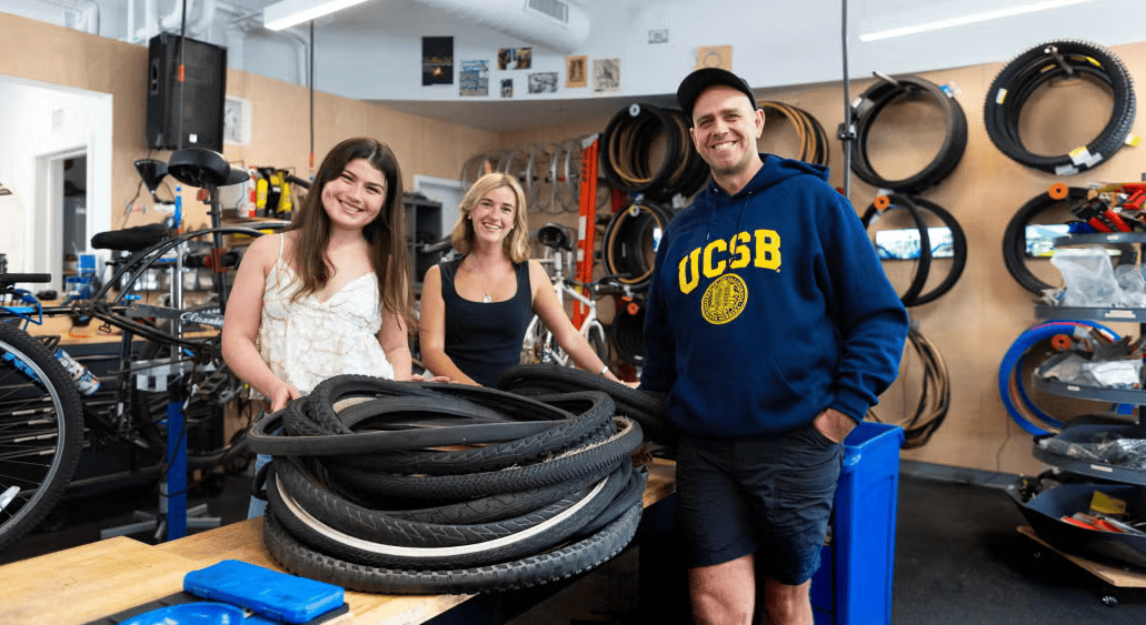 Environmental studies undergrads Sophia Long (left) and Virginia Such with A.S. Bike Shop Manager Adam Jahnke