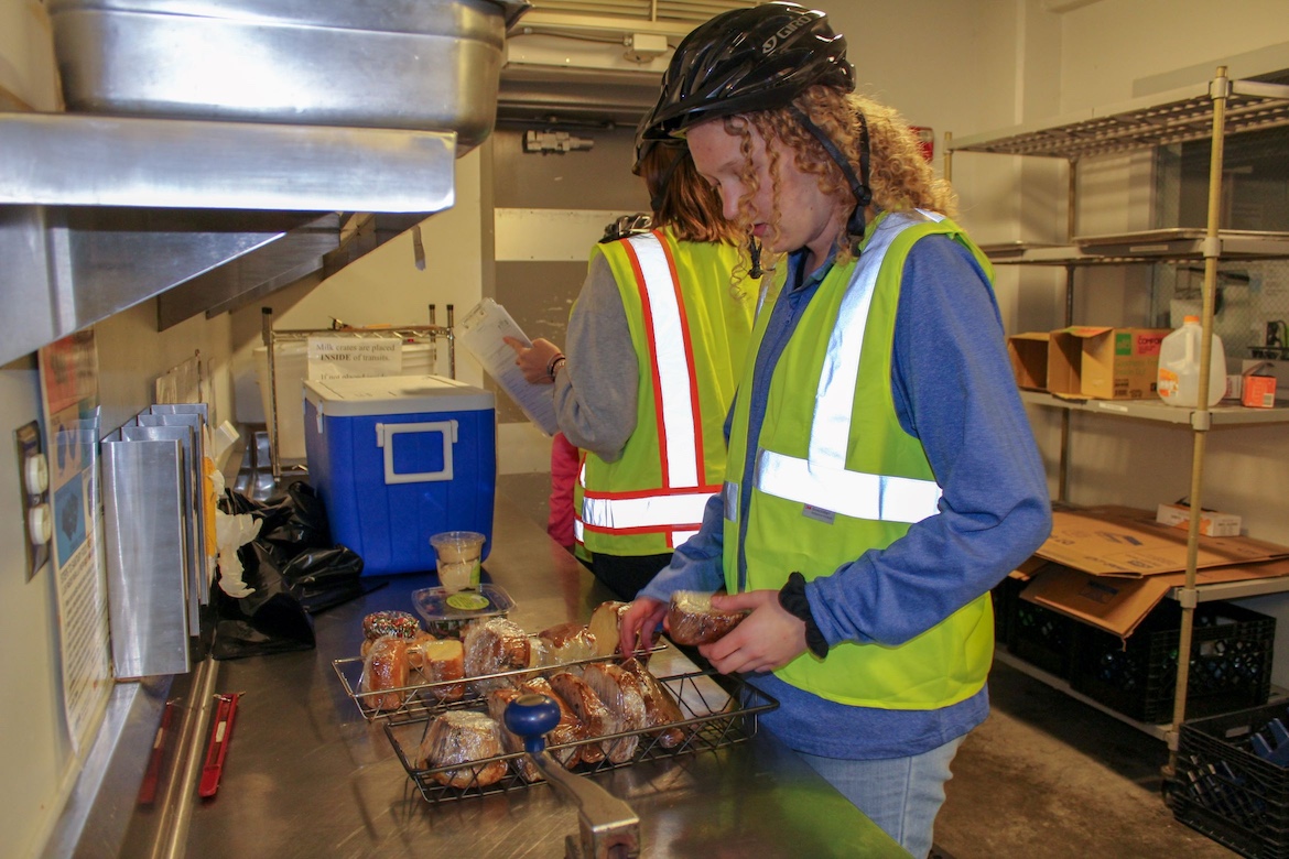 two student workers collecting food for recovery